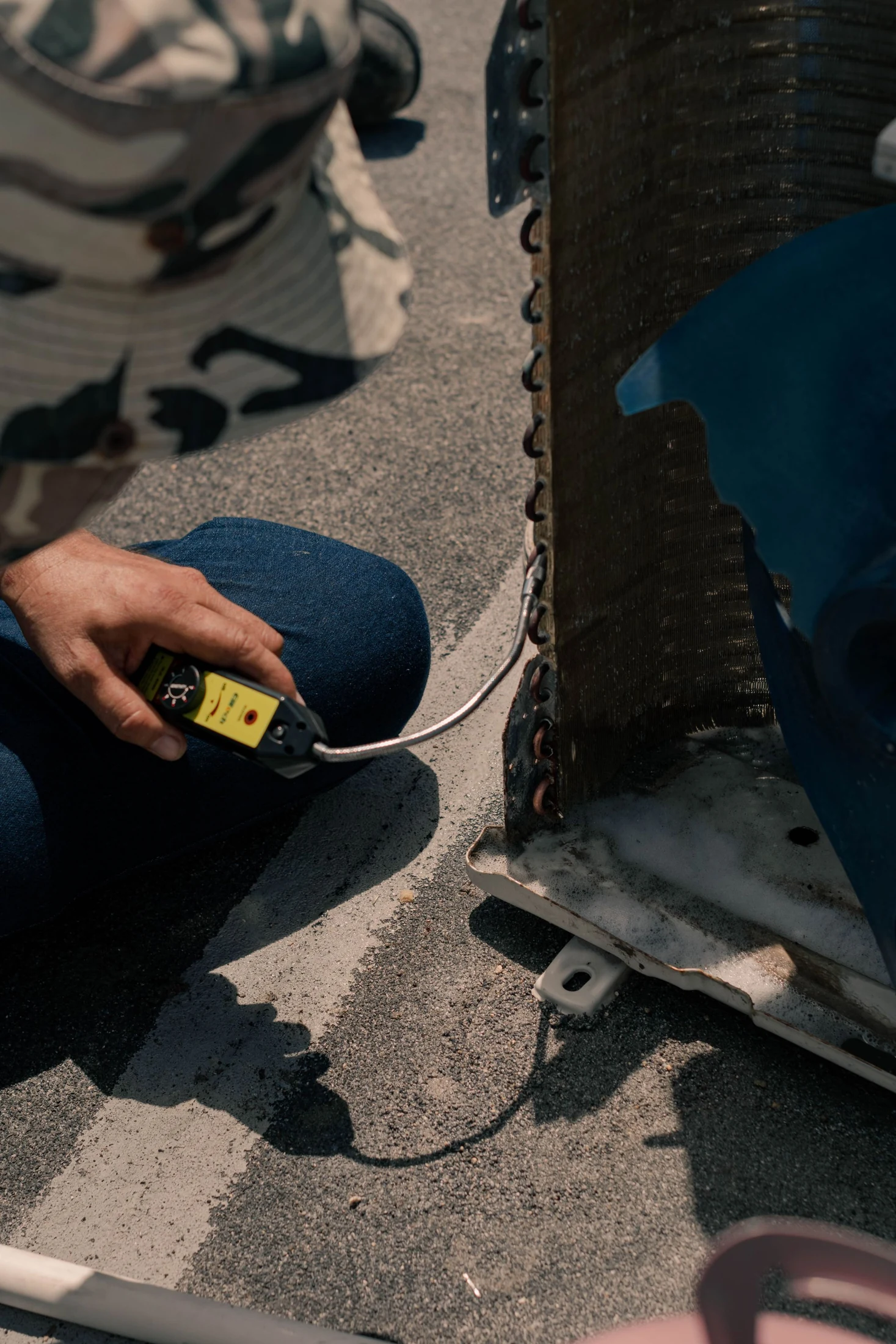 Technician inspecting an outdoor AC unit with maintenance tools