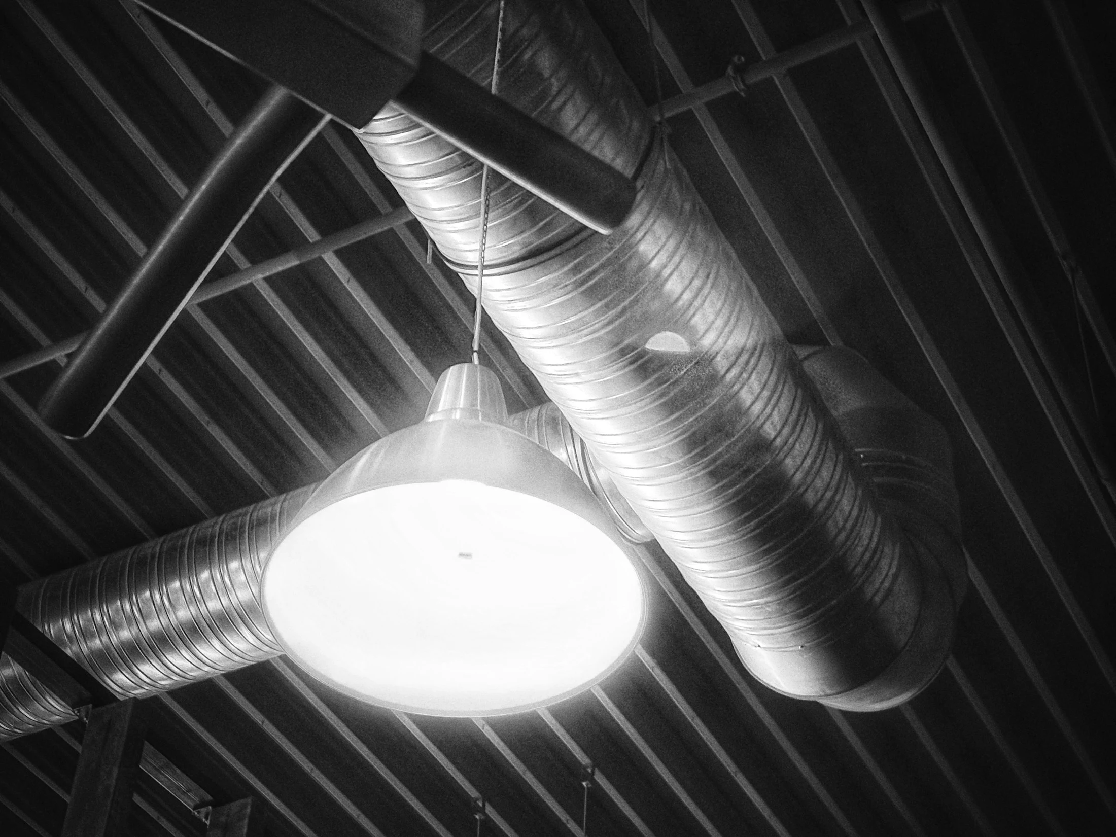 Metal ventilation ductwork across an industrial interior ceiling