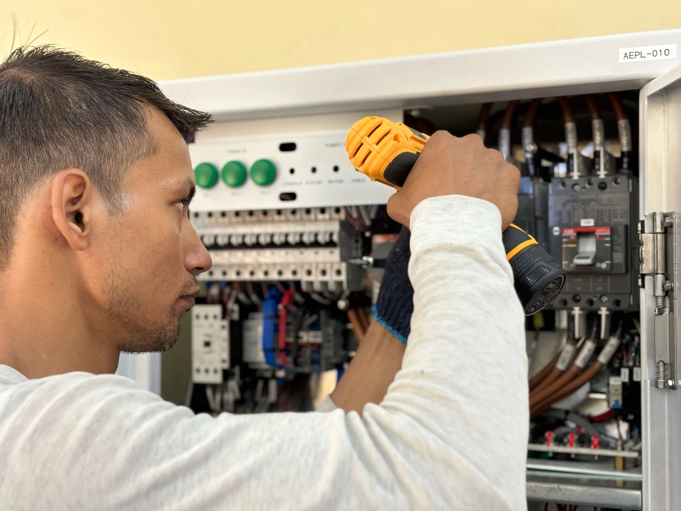 Electrician working on an indoor circuit breaker panel